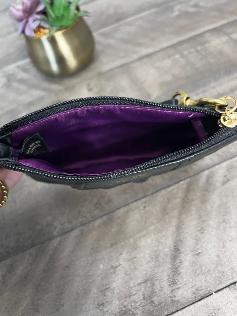 Madison black pebbled leather wristlet featuring gold-tone‎ hardware